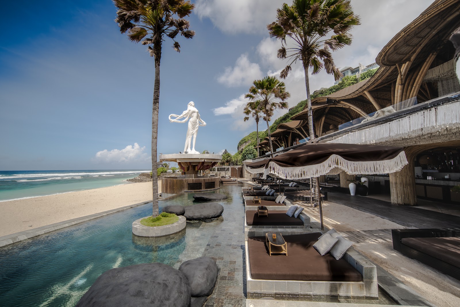 Adults-only beach club pool with a white statue overlooking the beach